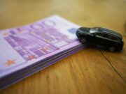 Stap eurobiljetten op tafel met een miniatuurauto