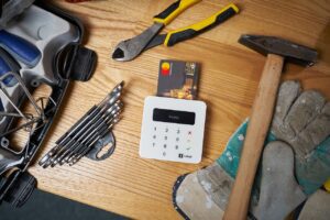 Een mobiel pinapparaat tussen verschillende gereedschappen op een tafel