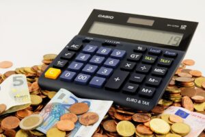 Een rekenmachine bovenop een grote hoeveelheid muntjes