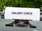 Typmachine met een vel papier waarop 'Salary check' staat.