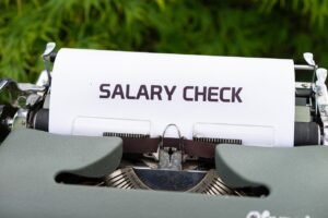 Typmachine met een vel papier waarop 'Salary check' staat.